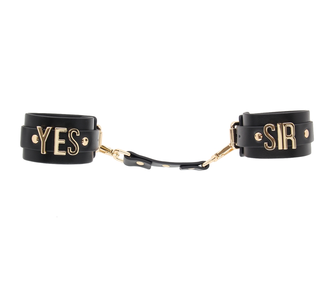 Love in Leather Yes Sir cuffs with gold hardware - premium leather BDSM wrist restraints with embossed text